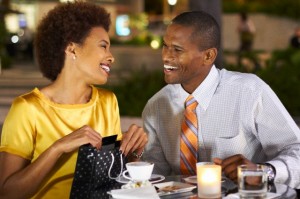 African American giving wife gift over dinner