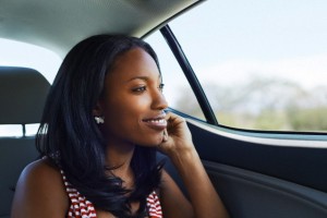 Portrait of young woman gazing through car backseat window