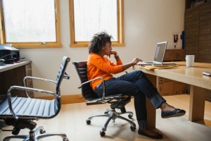 Woman sitting in room using laptop