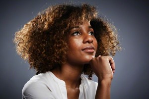 Portrait of young woman, hand on chin, looking up