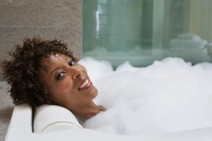 African American woman relaxing in bubble bath