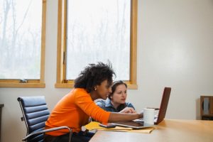 Two women using laptop