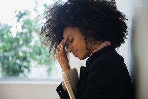Stressed mixed race businesswoman rubbing her forehead