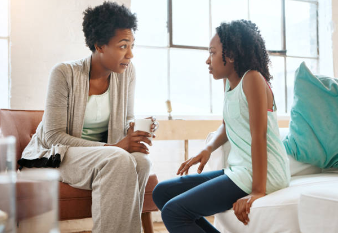 black mom talking to daughter - teaching her.